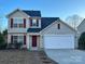 Two-story house with a two-car garage and a manicured lawn at 1021 Meadowbrook Sw Ln, Concord, NC 28027