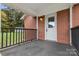 Covered porch with black railing and a white door at 2117 Charlotte Hwy, Mooresville, NC 28117