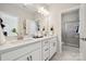 Double vanity bathroom with white cabinets and a large walk-in shower at 1414 Hubert Graham Way, Tega Cay, SC 29708