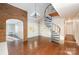 Living room featuring hardwood floors, a spiral staircase, and brick fireplace at 2643 Rolling Hills Dr, Monroe, NC 28110