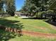 Large grassy side yard with a brick retaining wall at 538 Rowe Dr, Newton, NC 28658