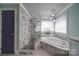 Bathroom with a soaking tub and walk-in shower, featuring marble tile at 211 Bullfinch Rd, Mooresville, NC 28117