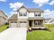 Two-story house with stone and siding exterior, two-car garage at 309 Contentment Dr, Locust, NC 28097