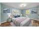 Virtually staged bedroom with light teal walls, hardwood floors, and ample natural light at 1251 Magnolia St, Albemarle, NC 28001