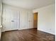 Well-lit bedroom with double doors, leading into another room, and dark brown wood-look flooring at 5536 Stowe Derby Dr, Charlotte, NC 28278