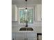Kitchen with double sink, white cabinets, and subway tile at 1018 Cross Creek Dr, Oakboro, NC 28129