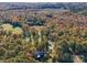 Aerial view of a house with a pool, surrounded by trees and open fields at 846 Windy Oaks Way, Lancaster, SC 29720