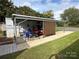 Covered patio with table, chairs, golf cart, and attached camper at 134 Dove Ln, New London, NC 28127