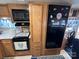 Well-equipped kitchen with wood cabinets and black appliances at 134 Dove Ln, New London, NC 28127
