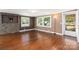 Living room with hardwood floors, stone accent wall, and neutral decor at 4108 Scarlet St, Matthews, NC 28104