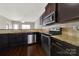 Modern kitchen features granite countertops, stainless steel appliances, and dark wood cabinets at 2013 Firefly Ln, Fort Mill, SC 29715