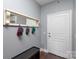 Bright entryway with coat hooks, mirror, and bench at 1315 East Blvd # 408, Charlotte, NC 28203