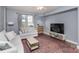 Living room with light sofa, coffee table, and large TV at 1315 East Blvd # 408, Charlotte, NC 28203
