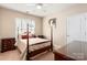 Bedroom with wooden post bed and window shutters at 45014 Wigeon Ln # 100, Indian Land, SC 29707