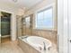 Bathroom with soaking tub, shower, and tile flooring at 18719 Bartlette Creek Dr, Davidson, NC 28036