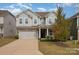 Two-story gray house with stone accents and a two-car garage at 3057 Burnello Ct, Iron Station, NC 28080
