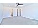 Large bedroom with grey carpet, ceiling fan, and en-suite bathroom at 205 Wedge View Way, Statesville, NC 28677