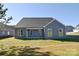Rear view of house; gray siding, covered patio, and yard at 103 Bunker Hill Ln, Statesville, NC 28677