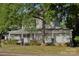 Two-story house with wrap-around porch, landscaping, and mature trees at 115 S Pearl St, Troy, NC 27371