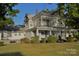 Two-story house with wrap-around porch and mature landscaping at 115 S Pearl St, Troy, NC 27371