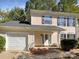 Two-story light beige home with attached garage and landscaping at 3128 Periwinkle Ct, Charlotte, NC 28269