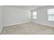 Spacious bedroom with neutral walls, carpet, and two windows at 4321 Stream Dale Nw Cir # 218, Concord, NC 28027