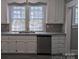 White kitchen cabinets, granite countertops, and stainless steel dishwasher at 602 W Council St, Salisbury, NC 28144