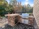 Outdoor kitchen with built-in grill, refrigerator, and stone countertops at 816 Pine Valley Ct, Weddington, NC 28104