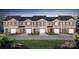 Front view of townhouses with attached garages and landscaping at 5119 Hyrule Dr, Charlotte, NC 28262