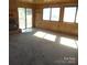 Large living room with carpeted floor and sliding glass door at 5150 Goodman Lake Rd, Salisbury, NC 28146