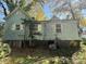 Older home with weathered siding, overgrown landscaping, and needs some TLC at 1115 Harrill St, Charlotte, NC 28205