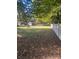 Large backyard with a wooden fence and scattered leaves at 3238 Campbell Dr, Charlotte, NC 28205