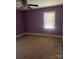 Simple bedroom with purple walls and carpeted floor at 3238 Campbell Dr, Charlotte, NC 28205