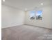 Well-lit bedroom with neutral carpeting and two large windows at 748 Olde England Dr, Lincolnton, NC 28092