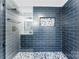 Walk-in shower with blue tile and pebble floor at 1232 Eisenhower Rd, Rock Hill, SC 29730