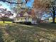 Charming yellow farmhouse with red metal roof and rocking chairs on porch at 16409 Silver Rd, Oakboro, NC 28129