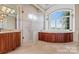 Spa-like bathroom with a large soaking tub, walk-in shower, and window views at 590 Tuckertown Rd, New London, NC 28127