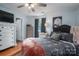 Bedroom with gray upholstered bed, ceiling fan, dresser, and large window with curtains at 620 N Oak St, Lincolnton, NC 28092