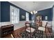 Elegant dining room with dark blue walls, hardwood floors, and a glass-top table at 1017 N Sharon Amity Rd, Charlotte, NC 28211