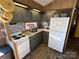 Efficient kitchen with gray cabinets, white appliances, and mosaic backsplash at 104 Cardinal Ave, New London, NC 28127