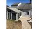 Rear view of a house featuring a sunroom and gravel patio at 8540 Indian Summer Trl, Harrisburg, NC 28075