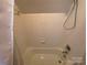 Small bathroom with shower/tub combo and white tiled walls at 103 Berea Baptist Church Rd, Stanfield, NC 28163