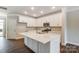 Modern white kitchen with island, stainless steel appliances, and tile backsplash at 5540 Stafford Rd # 31, Charlotte, NC 28215