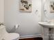 Clean and modern bathroom with pedestal sink, toilet, and decorative art at 435 Riverwalk Nw Dr, Concord, NC 28027