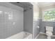 Gray tiled bathroom with shower/tub combo at 1102 W Elm St, Shelby, NC 28152