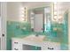 Retro bathroom with mint green tile and vanity featuring a large mirror and Hollywood lighting at 1102 W Elm St, Shelby, NC 28152