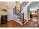 Elegant staircase with wrought iron balusters and hardwood floors at 10008 Cuyo Ct, Tega Cay, SC 29708