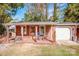 Cozy cottage with rocking chairs on the porch, attached garage and nicely manicured lawn at 834 Brookwood Dr, Mooresville, NC 28115