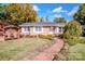 Brick ranch house with landscaped lawn, brick walkway, and a charming wooden arbor at 834 Brookwood Dr, Mooresville, NC 28115