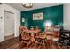 Small dining area with wood table and chairs, green accent wall, and wood floors at 834 Brookwood Dr, Mooresville, NC 28115